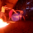Zwei Frauen und Männer neben Lagerfeuer