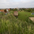 Weitblick von oben auf großes Gartengelände mit Rasen und Trampolin