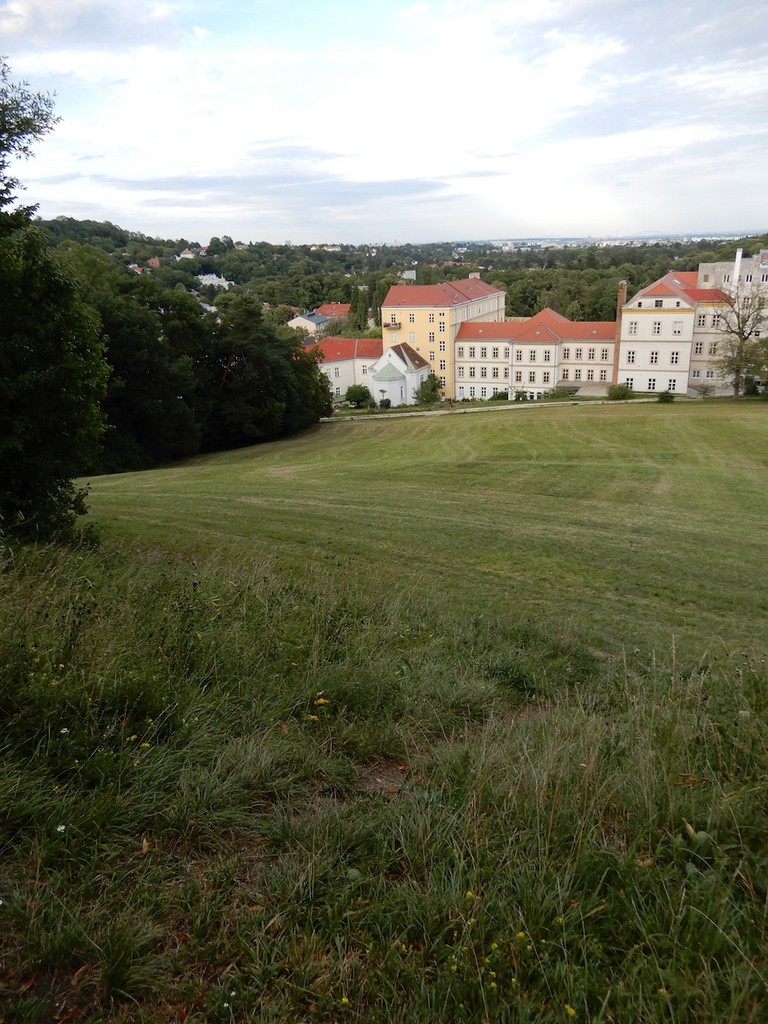 Blick von einem Hügel über Wiesen auf BROT Kalksburg