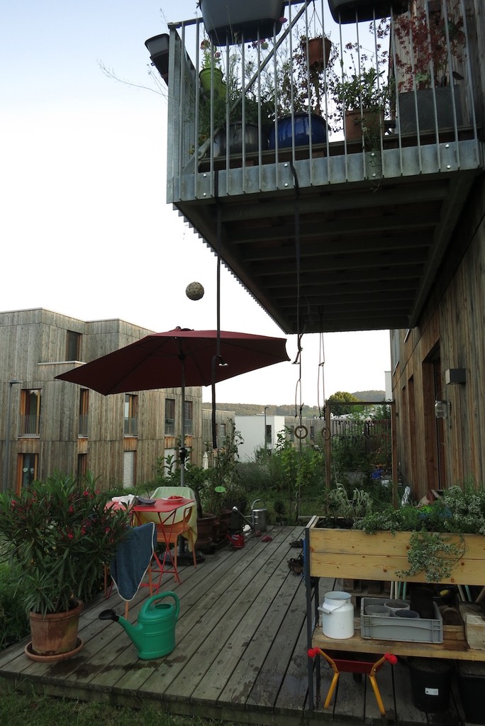 Begrünte Terrasse mit Hochbeet und darüberliegender Balkon
